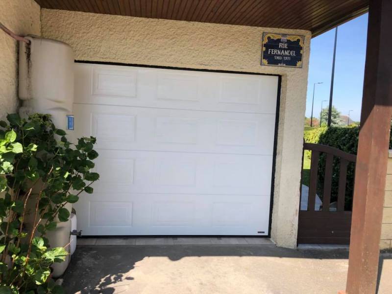 Entreprise pour l'installation d'une porte de garage blanche motorisée 